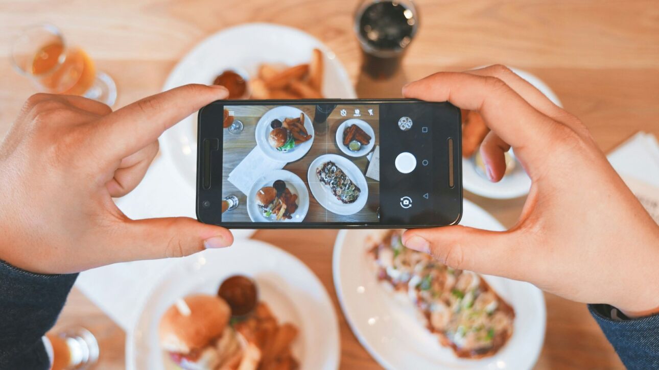 person taking picture of the foods