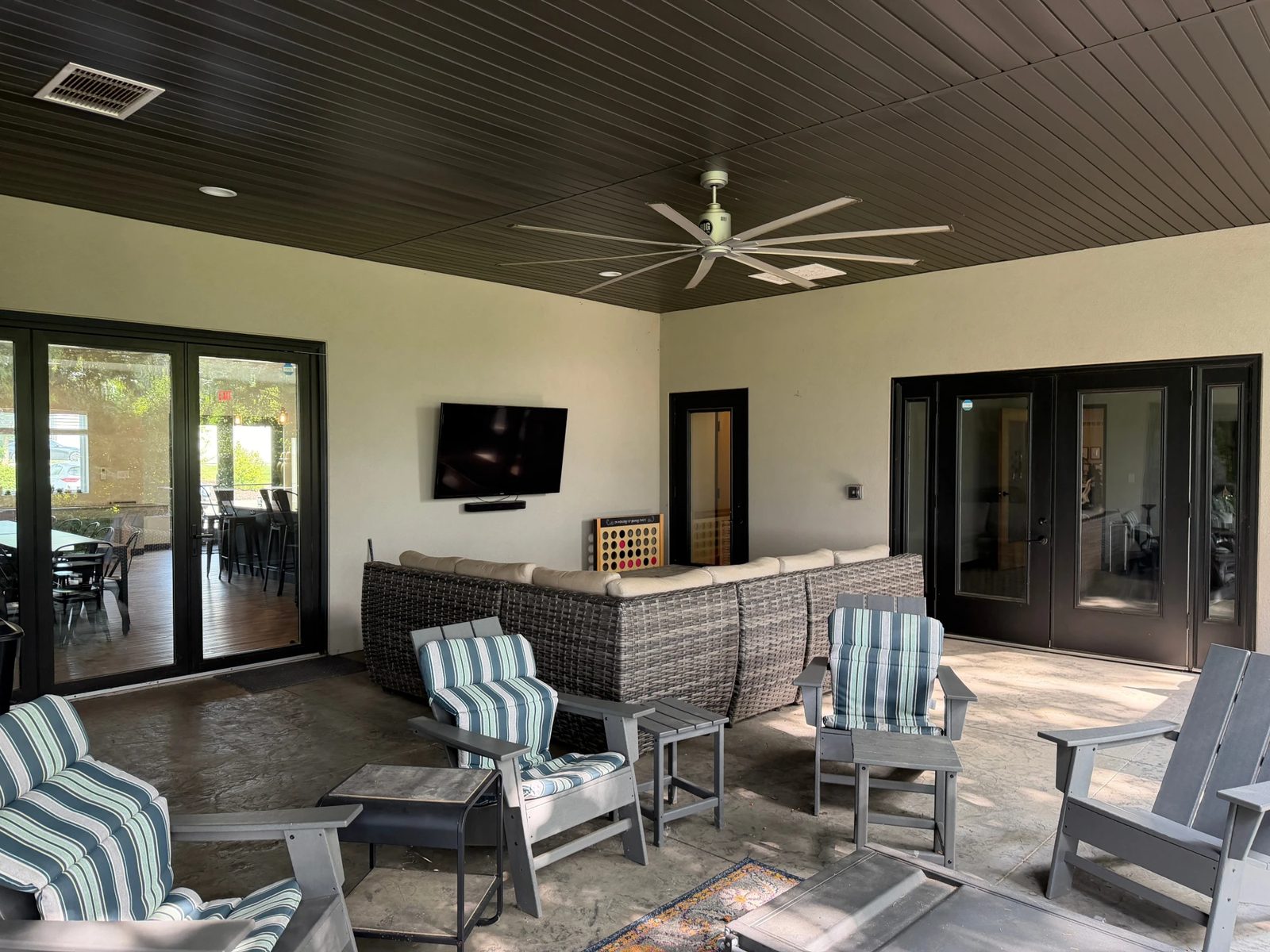 Covered patio lounge with outdoor seating and a TV